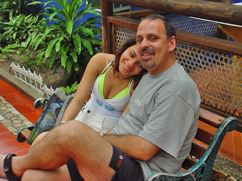 A photo of a foreign man with a Cartagena woman leaning on his shoulder